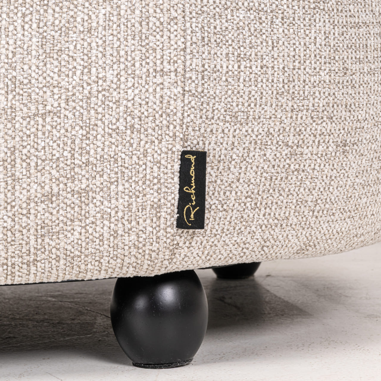 tissu-natural-fancy-richmond-amelia Détail pied rond noir et étiquette Richmond, canapé Amelia beige, tissu natural fancy